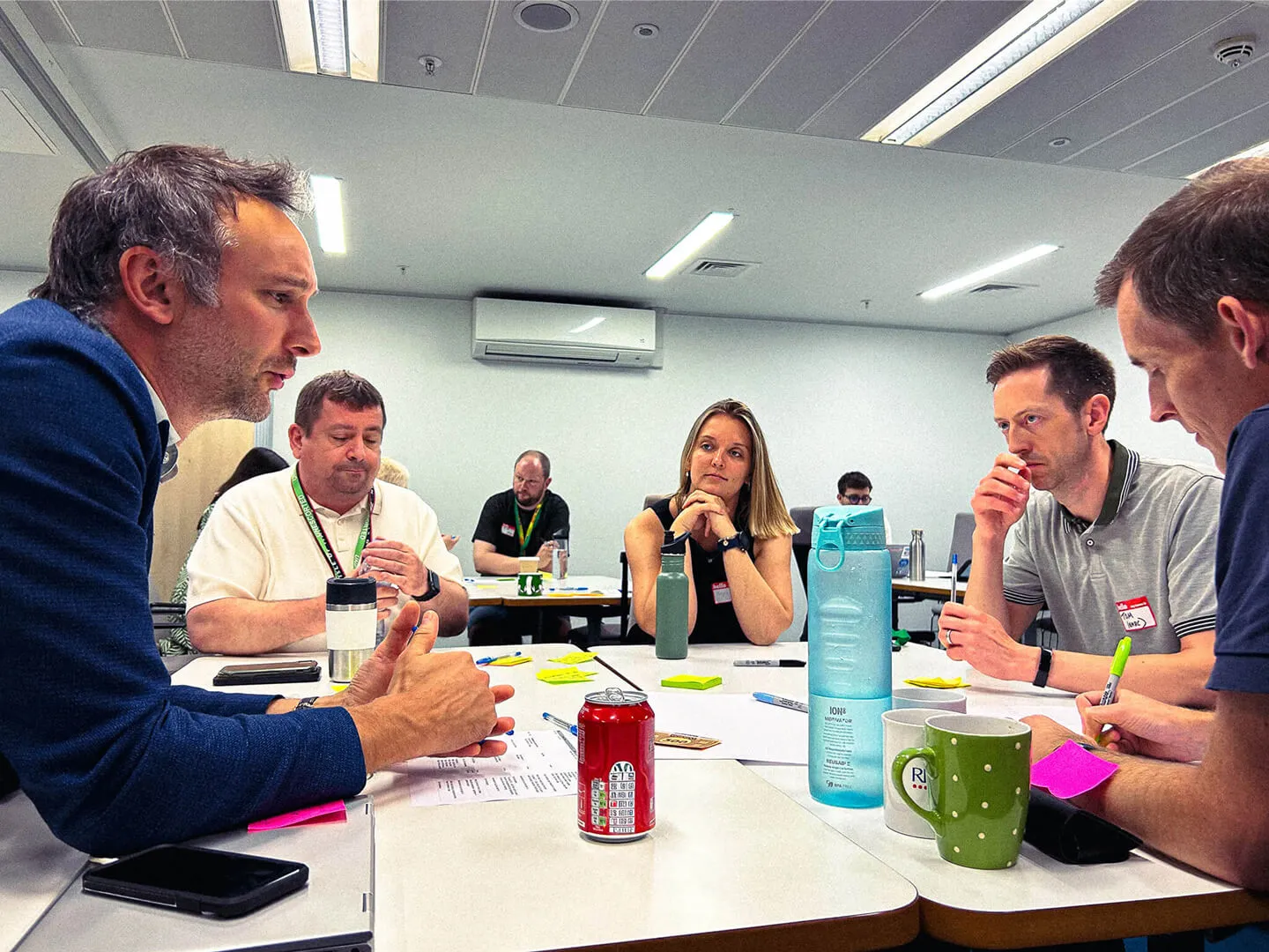 Group of people at a table engaged in discussion in a conference room.